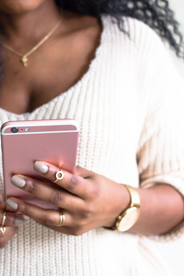 Black woman holding a pink cell phone